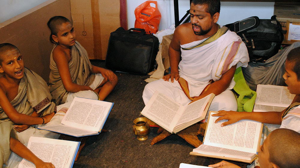 Indian man teaching boy the Veda-s